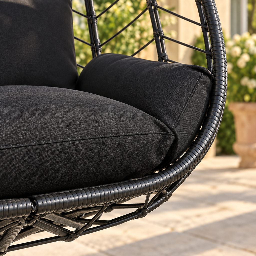 Gros plan sur la couture du coussin anthracite et le tressage noir du fauteuil œuf