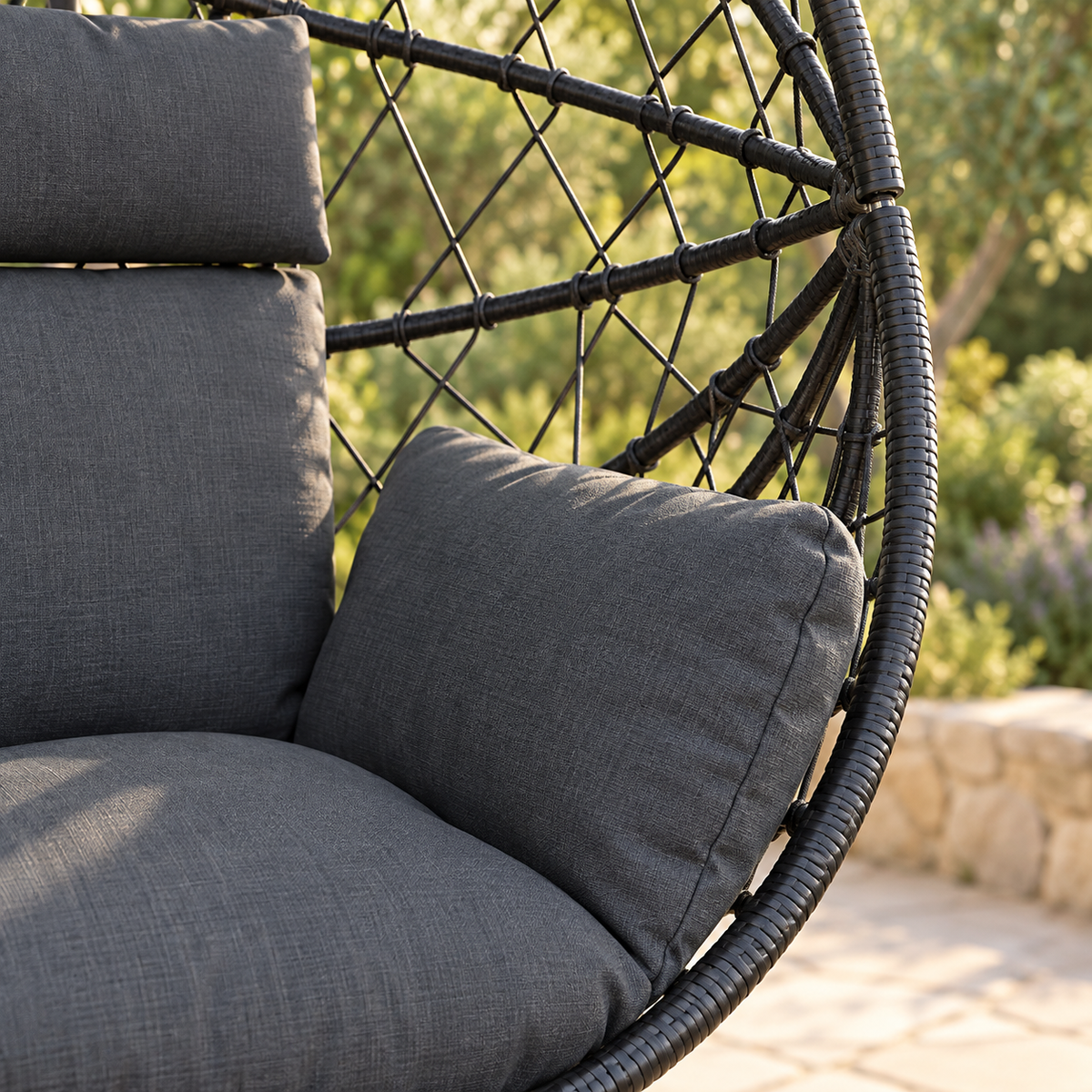 Détail des matières et des coussins de la fauteuil œuf sur pied en rotin foncé avec coussins anthracite