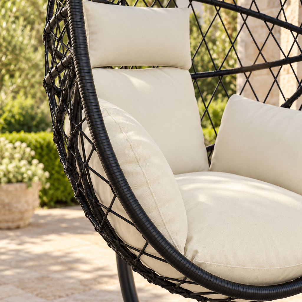 Détail des matières et des coussins de la fauteuil œuf sur pied en rotin foncé avec coussins crème