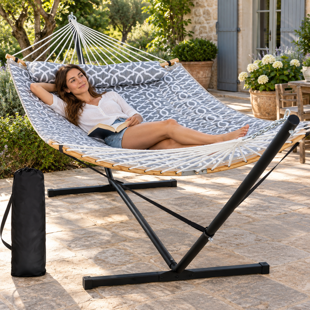 Hamac matelassé gris clair à motif avec support acier utilisé par une personne dans un jardin