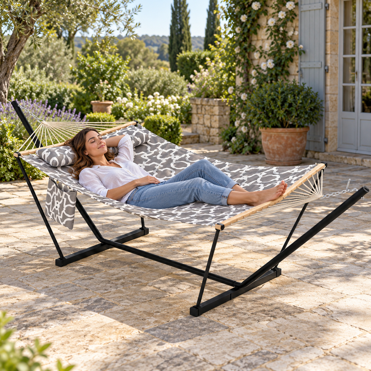 Hamac matelassé gris blanc à motif avec support acier en utilisation dans un jardin ou sur une terrasse