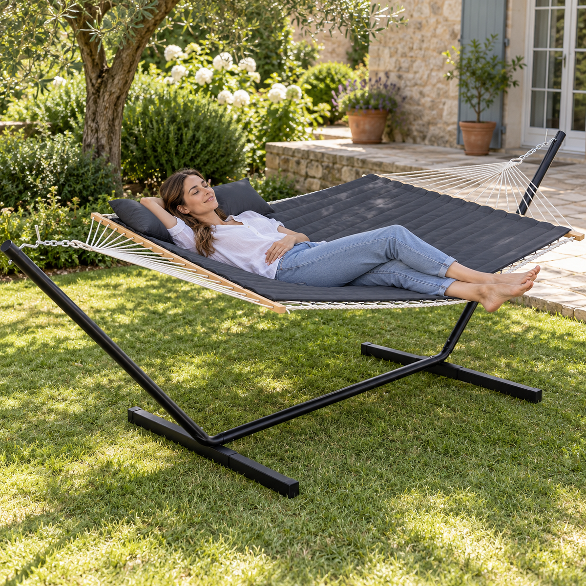 Hamac en corde gris foncé uni avec matelas et support acier en utilisation dans un jardin ou sur une terrasse