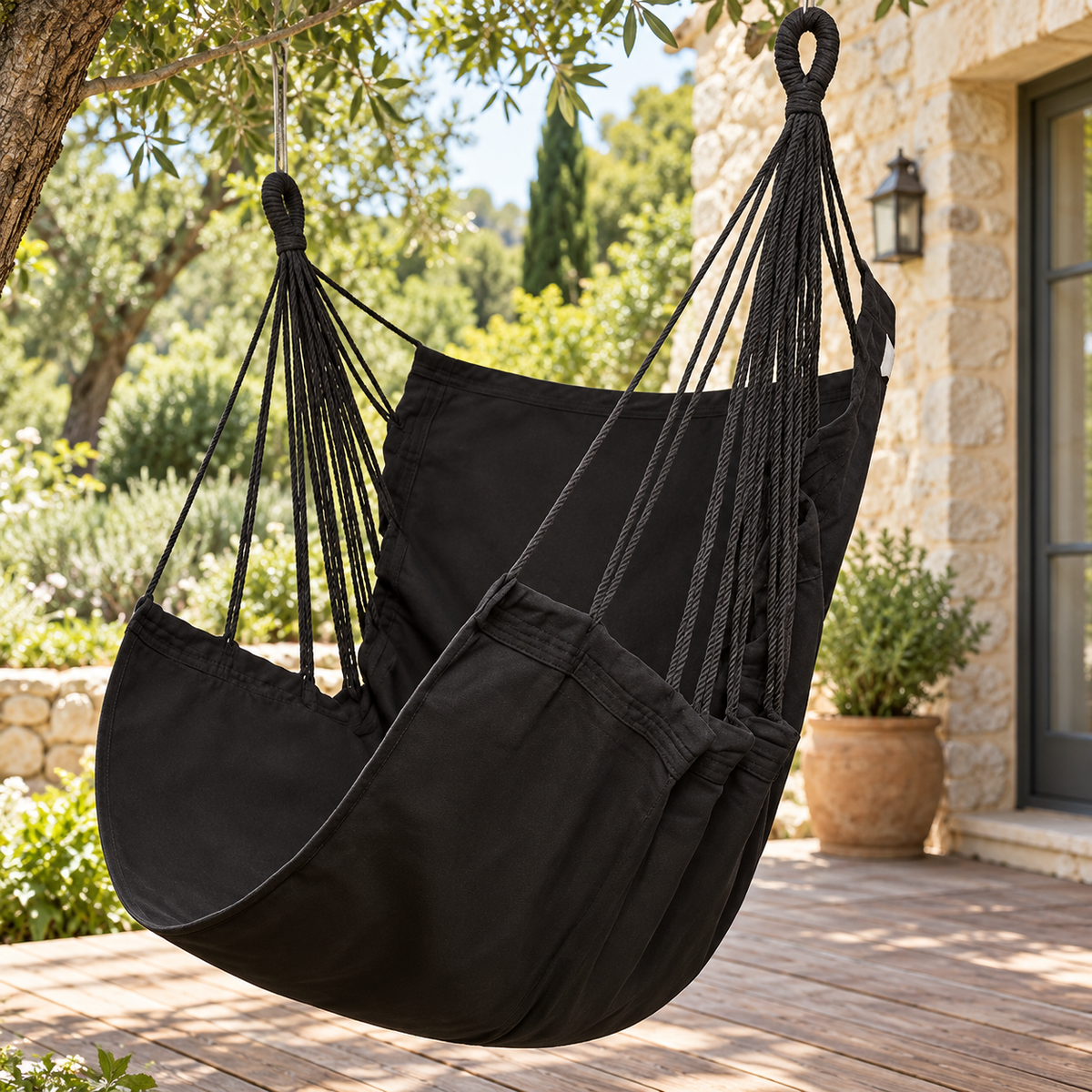 Chaise hamac en toile noire sans barre, vue de trois quarts dans un jardin