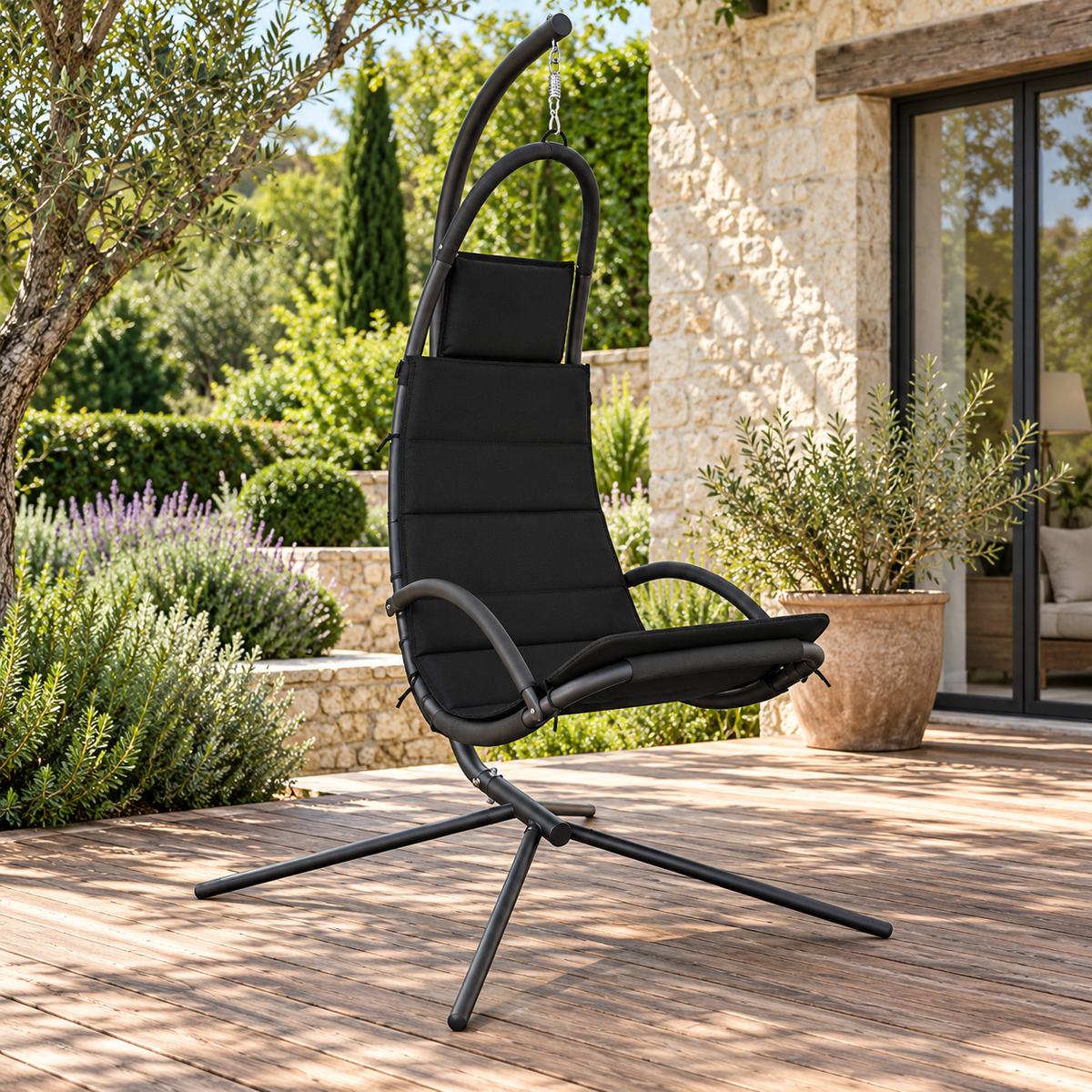 Fauteuil suspendu noir en tissu Oxford avec pied, vue de trois quarts dans un jardin