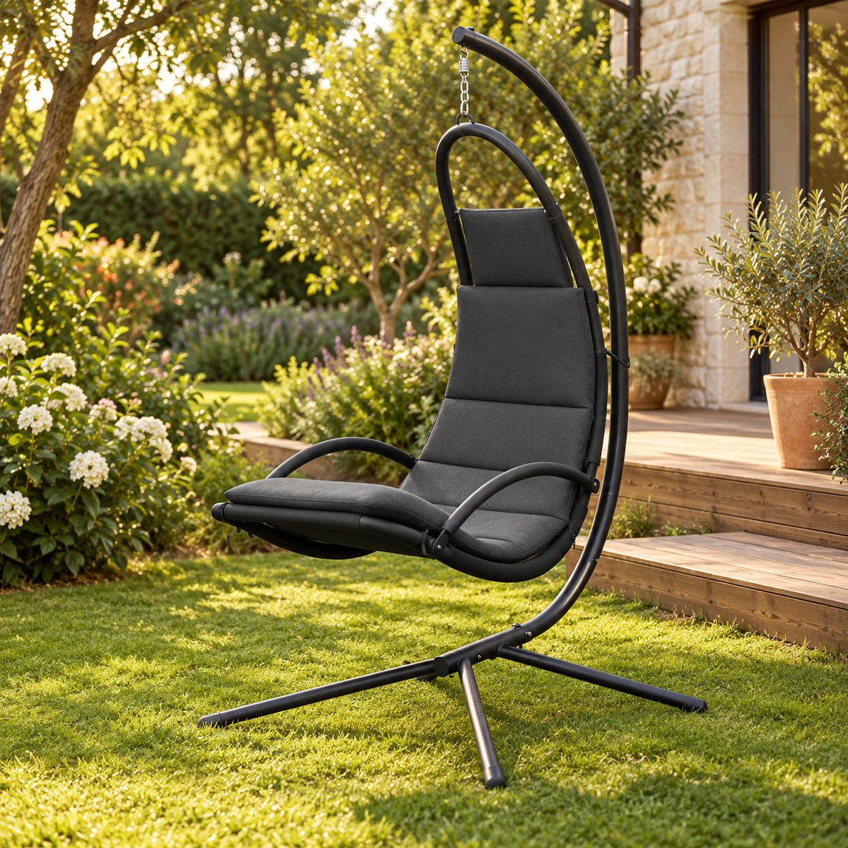 Fauteuil suspendu gris foncé en tissu Oxford avec pied, vue de trois quarts dans un jardin