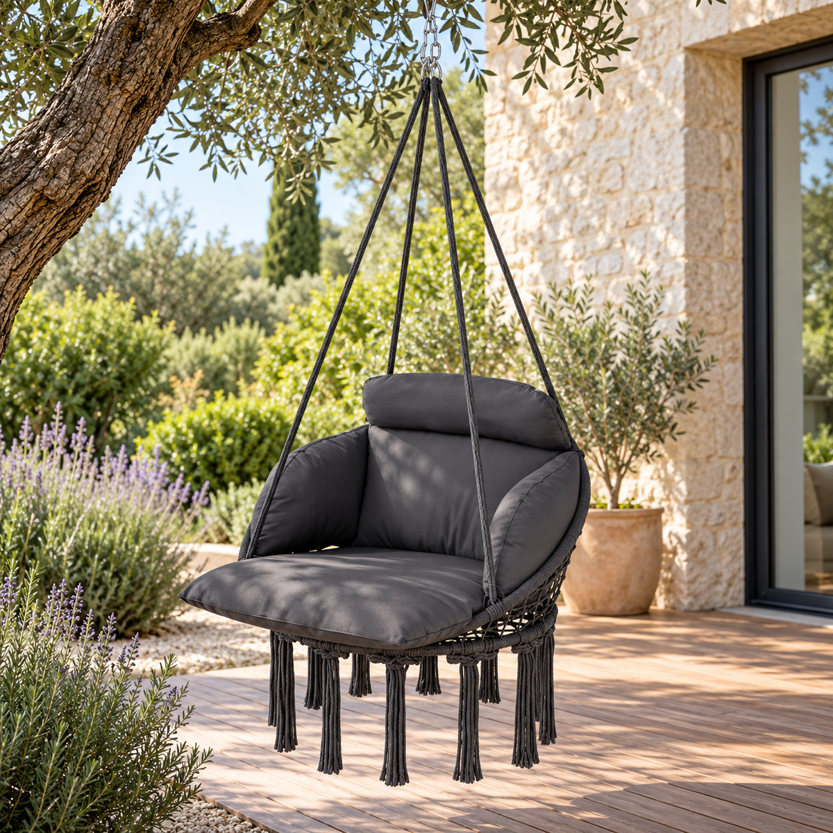 Fauteuil suspendu en macramé anthracite avec chaîne, vue de trois quarts dans un jardin