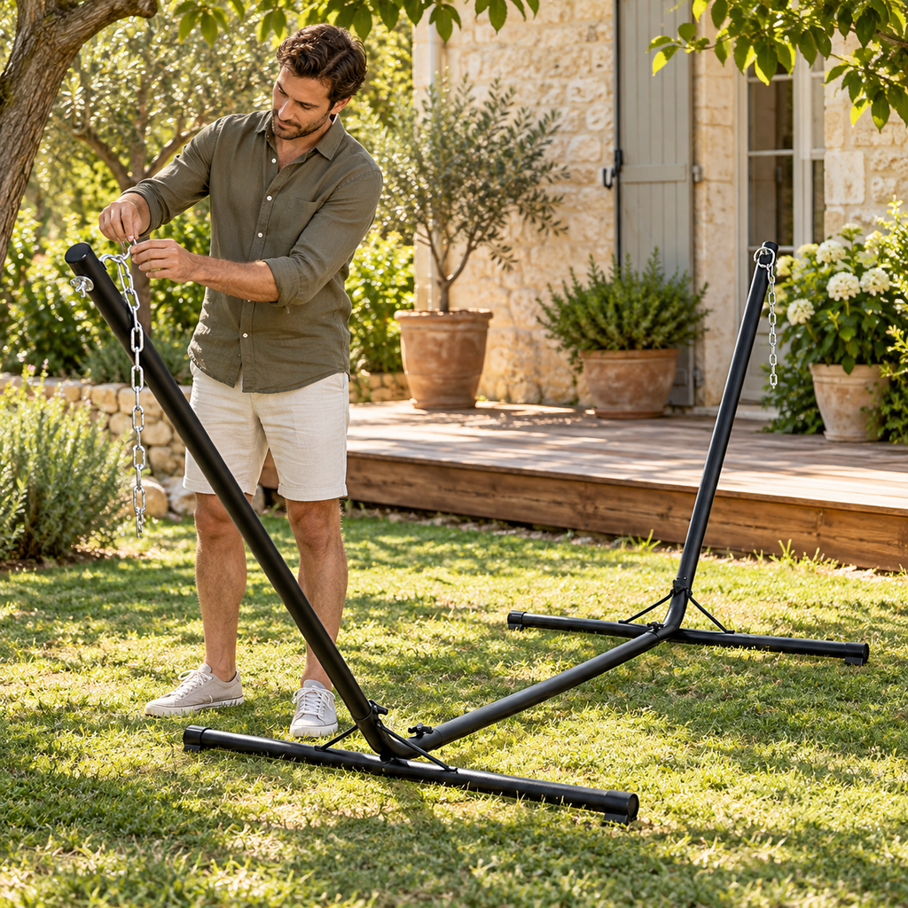 Personne réglant la chaîne de fixation du support de hamac en acier noir dans un jardin