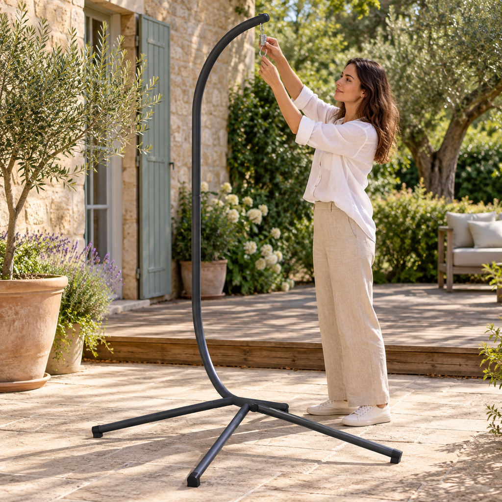 Personne réglant le ressort de suspension du pied anthracite pour fauteuil œuf dans un jardin